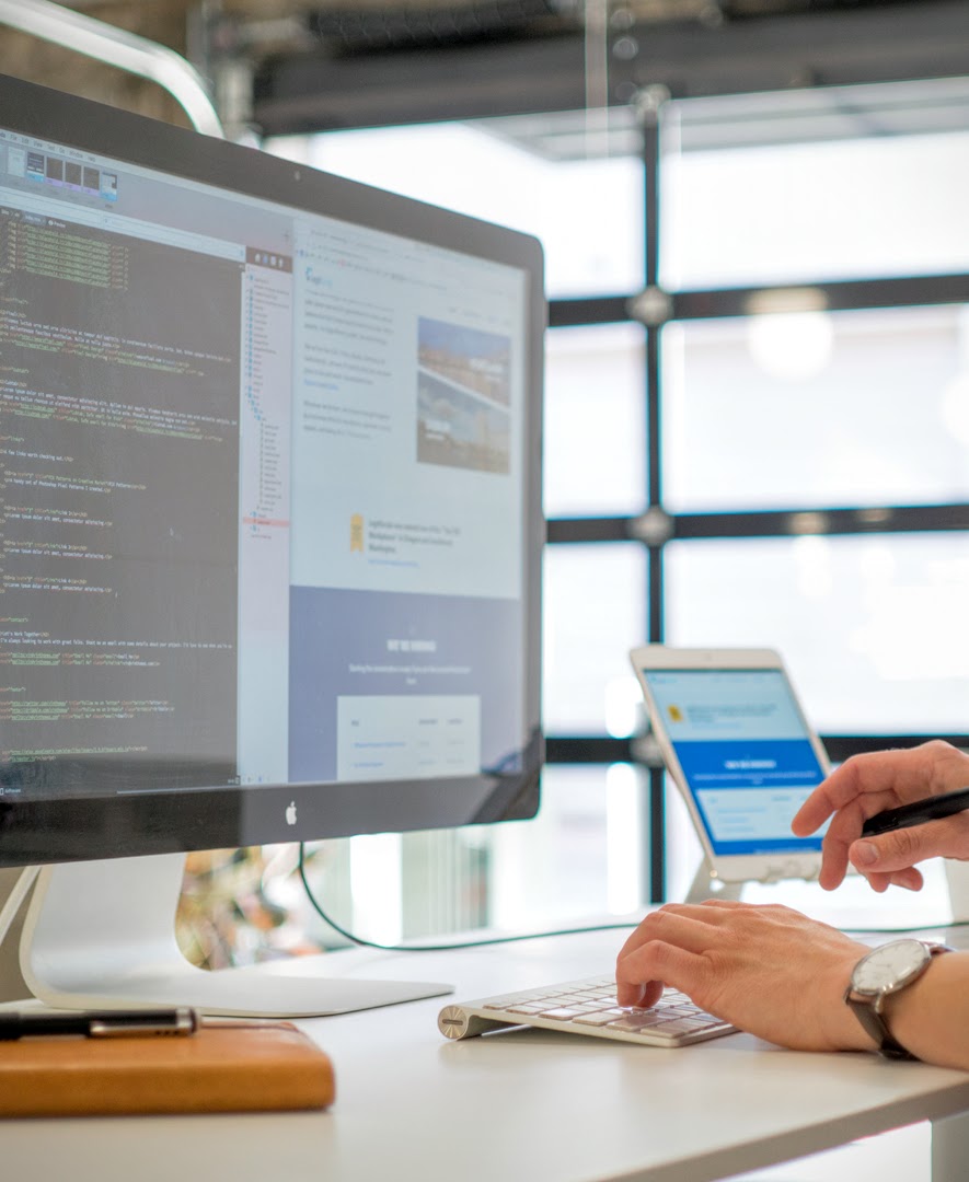 A strategist working at a desk with multiple screens and devices in a modern studio